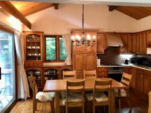 a kitchen with a wooden table and chairs and a chandelier at Cottage 62 Seseraginomori Kyu-karuizawa in Karuizawa