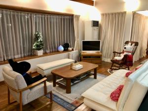 a living room with a couch and a table at Cottage 62 Seseraginomori Kyu-karuizawa in Karuizawa