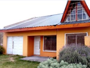 una casa con dos puertas de garaje y un techo en La Casita de Carla en Quequén