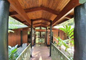 a wooden walkway to a house with a wooden ceiling at BUTTERFLY BEND - 3 Bedroom Daintree Beach House in Cow Bay