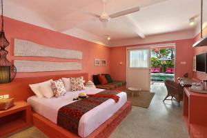 a bedroom with a large bed and a living room at PinkCoco Gili Trawangan - for Cool Adults Only in Gili Trawangan