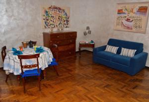 Una sala de estar con una mesa y un sofá azul. en La Casetta di Zio Mario, en Roma