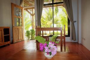 a room with a vase of flowers on a wooden floor at Island View Beachfront Resort in Anda