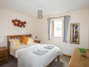 a bedroom with a bed and a window at Sandy Toes in Rhosneigr