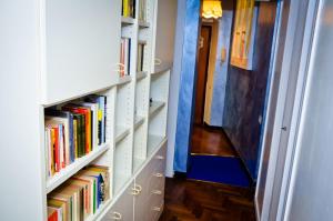 un pasillo con estanterías blancas llenas de libros en La Casetta di Zio Mario, en Roma
