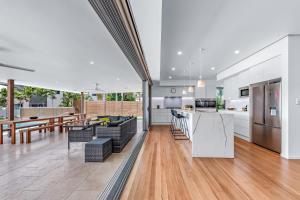 an open kitchen and living room with wood floors at Whitsunday living on Hillcrest in Airlie Beach