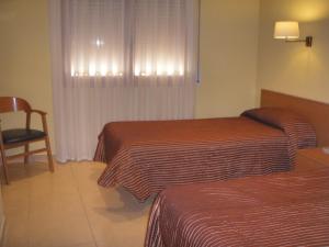 A bed or beds in a room at Hostal Mallorquines
