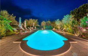 a swimming pool at night with chairs and umbrellas at Villa Luca in Vitorchiano