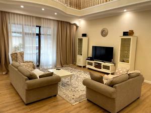 a living room with two chairs and a flat screen tv at Mountain Garden & SPA in Besqaynar