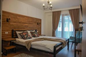 a bedroom with a large bed with a wooden headboard at Chalet Mugure de Brad in Fundu Moldovei