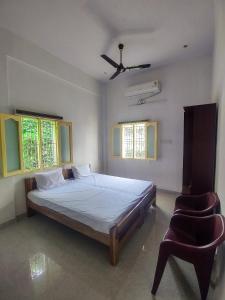 1 dormitorio con 1 cama y 1 silla en Hotel Padma Shree , Madurai - Near Airport en Madurai