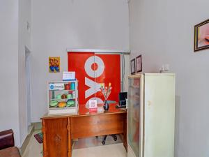 Habitación con escritorio y nevera. en SUPER OYO 1356 Gusti Residence en Dalung