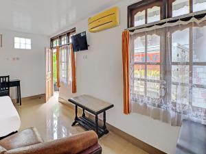 a living room with a table in front of a window at SUPER OYO 1356 Gusti Residence in Dalung