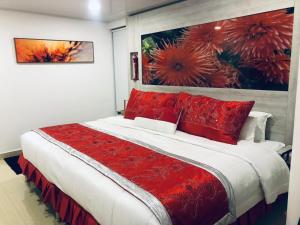 a bedroom with a large bed with red pillows at Hotel San Antonio Guarne in Guarne
