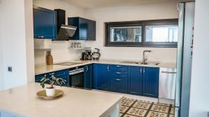 a kitchen with blue cabinets and a sink at Villa Çimentepe in Bodrum City