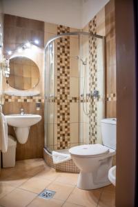a bathroom with a toilet and a shower and a sink at Manzard Panzio in Budapest
