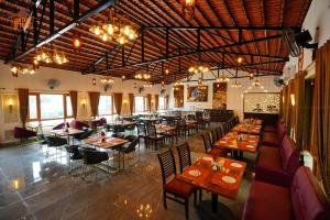 - un restaurant avec des tables et des chaises dans une salle dans l'établissement Vintage Retreat Resort, à Bīdar