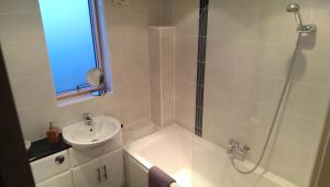 a white bathroom with a shower and a sink at South House in Winchester +10 photos