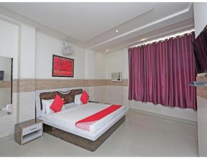 a bedroom with a large bed with red pillows at Royal Comfort Cottage, Panipat in Pānīpat