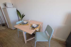 een eettafel met 2 stoelen en een koelkast bij L'Évasion - Studio - Vue mer in Calais