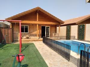 uma casa com piscina com putting green em شاليهات الكوخ السويسري وأكوابارك em Ash Shishah