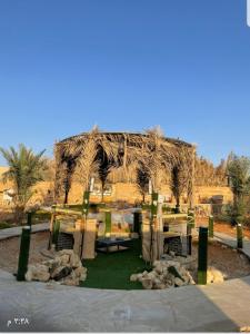 um pavilhão no meio de um deserto com árvores em استراحة لبنان ا في بنبان Istraha em Riade