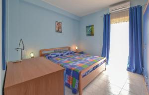 1 dormitorio con 1 cama, vestidor y escritorio en Stunning Home In Motta Camastra With Kitchen, en Motta Camastra