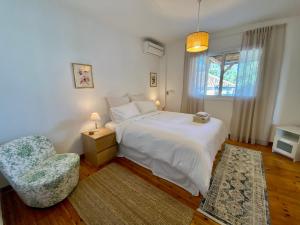 ein Schlafzimmer mit einem weißen Bett und einem Stuhl in der Unterkunft Liberty House - Central Two Bedroom Apartments in Nikosia