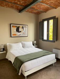 a bedroom with a large white bed with two windows at Cascina Mora Bassa in Vigevano
