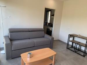 a living room with a couch and a table at ENTRE RIVIERE ET FORET in Vallon-Pont-dʼArc