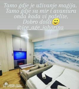 a living room with a couch and a painting on the wall at Apartman Ice age Jahorina in Jahorina