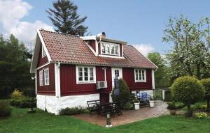 una casa roja y blanca con una mesa en el patio en Amazing Home In Slvesborg With Kitchen, en Hällevik