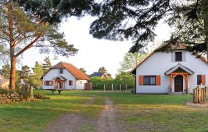 une maison blanche avec un arbre et un chemin de terre dans l'établissement 4 Bedroom Lovely Home In Fuhlendorf, à Fuhlendorf