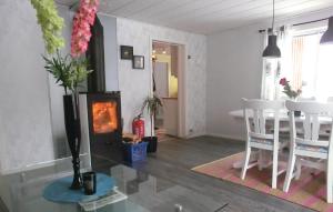 a living room with a fireplace and a table and chairs at 3 Bedroom Stunning Home In Annerstad in Annerstad