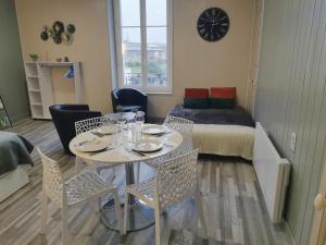 a room with a table and chairs and a bed at VITTEL LOC'S - Le 215 Classé 4 étoiles, Spacieux et calme in Vittel