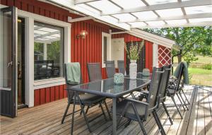 a patio with a table and chairs on a deck at Nice Home In Figeholm With 4 Bedrooms And Wifi in Figeholm