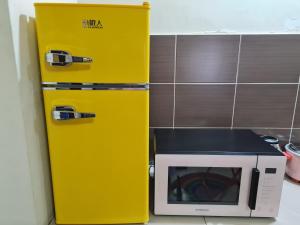 - un réfrigérateur jaune à côté d'un four micro-ondes dans l'établissement IPSA Lego Amari Water Park Lagoon Resort Bukit Katil Melaka, à Malacca