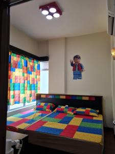 Schlafzimmer mit farbenfrohem Bett und Wandgemälde in der Unterkunft IPSA Lego Amari Water Park Lagoon Resort Bukit Katil Melaka in Malakka + 34 Fotos