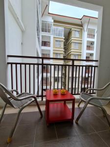 d'une table rouge et de deux chaises sur un balcon. dans l'établissement IPSA Lego Amari Water Park Lagoon Resort Bukit Katil Melaka, à Malacca
