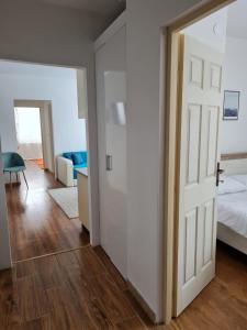 1 dormitorio con puerta blanca y cama en DDDD Apartament, en Cavnic