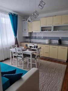 een keuken met een tafel en stoelen in een kamer bij DDDD Apartament in Cavnic