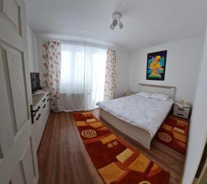 een kleine slaapkamer met een bed en een raam bij DDDD Apartament in Cavnic