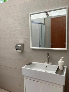 a bathroom with a white sink and a mirror at Canopy Villa Nuang Hill in Bentong