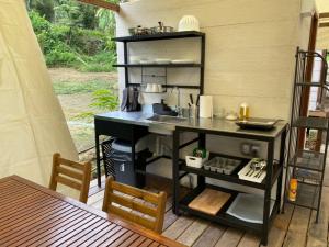 Canopy Villa Nuang Hill في بينتونغ: مطبخ على شرفة مع طاولة وكراسي