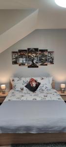 ein Schlafzimmer mit einem Bett mit vier Bildern an der Wand in der Unterkunft Apartamenty u Maksa in Krzywcza