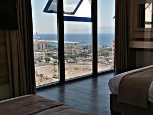 1 dormitorio con vistas al océano desde una ventana en ALENA HOTEL, en Áqaba
