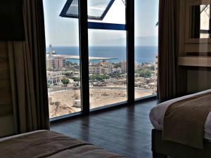 una camera da letto con finestra affacciata sull'oceano di ALENA HOTEL ad Aqaba
