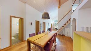 jadalnia z drewnianym stołem i fioletowymi krzesłami w obiekcie Palois Family Apartment Centre Lenzerheide w mieście Lenzerheide