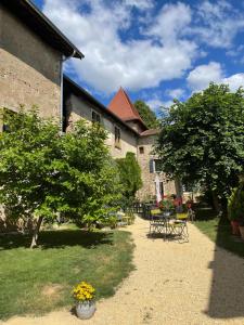 ogród ze stołem, krzesłami i drzewami w obiekcie Chateau de la Saone w mieście Lens-Lestang