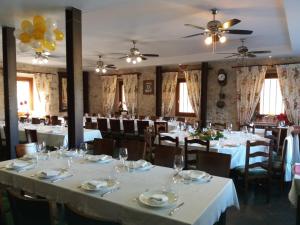 a dining room with white tables and chairs at MolinoGrande del Duratón in San Miguel de Bernúy